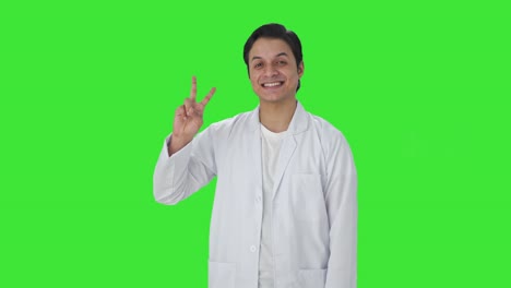 Happy-Indian-scientist-showing-victory-sign-Green-screen
