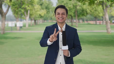 Happy-Indian-reporter-showing-victory-sign