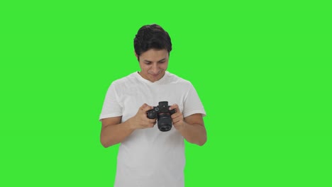 Happy-Indian-man-clicking-photos-using-camera-Green-screen