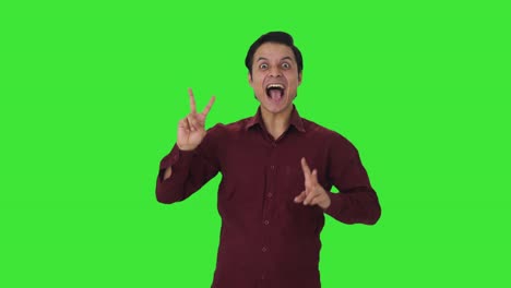 Happy-Indian-teacher-showing-victory-sign-Green-screen