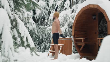 Caucasian-man-warming-up-before-winter-swim-in-barrel.