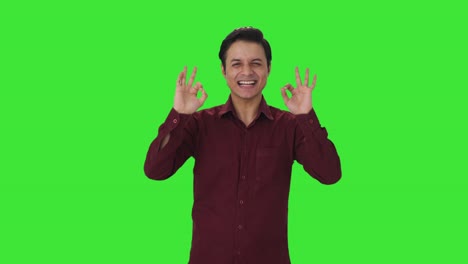 Happy-Indian-teacher-showing-okay-sign-Green-screen
