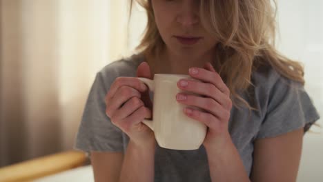 Teil-Einer-Frau-Mit-Einer-Tasse-Heißen-Kaffee,-Die-Morgens-Im-Bett-Aufwacht