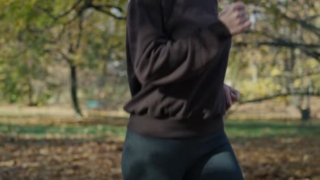 Tilt-up-of-caucasian-ginger-woman-jogging-at-the-park-in-autumn