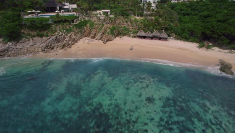 Overhead-drone-shot-of-a-beautiful-blue-and-green-beach-on-the-pacific-ocean-in-huatulco-mexico