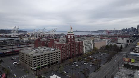 Langsame-Luftumlaufbahn-Des-Starbucks-Kaffeehauptquartiers-Elliot-Bay-Und-Der-Skyline-Von-Seattle,-Trüber-Grauer-Himmel