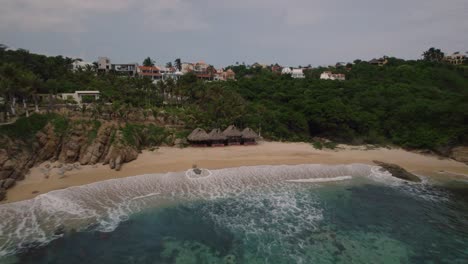 Aerial-Panorama-of-Turquoise-Waters-and-Rocky-Coastline-in-Huatulco,-Mexico,-with-Crashing-Waves