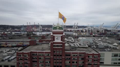 Clockwise-aerial-orbit-of-Starbucks-Coffee-Headquarters-Elliot-Bay-and-the-port-of-Seattle,-dull-gray-skies