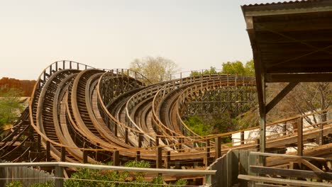 Aufnahme-Eines-Tomahawk-Zugs,-Der-An-Einem-Sonnigen-Tag-An-Einer-Holzachterbahn-In-Port-Aventura-World-In-Salou,-Spanien,-Vorbeifährt