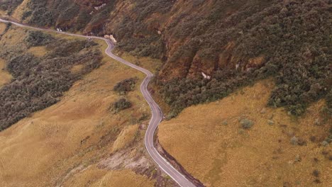 Aerial-view-of-a-road-in-the-middle-of-a-mountain-surrounded-by-trees