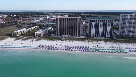 Vergrößern-Sie-Die-Luftaufnahme-Eines-Resorts-Am-Wasser-Mit-Buntem-Sonnenschirm-Und-Strandkorb-Am-Sandstrand-Des-Golfs-Von-Mexiko-In-Fort-Walton-Beach-Auf-Der-Insel-Kalaoosa-Im-Bundesstaat-Florida