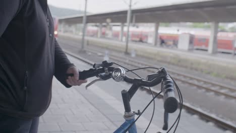 Man-with-his-bicycle-waits-for-high-speed-electric-train-at-station-in-Stuttgart,-Germany