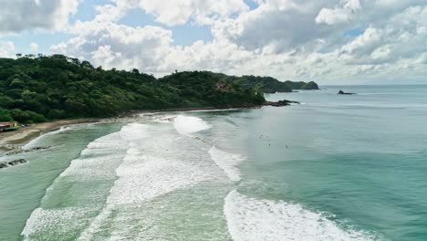 Surfer-paradise-in-Nicaragua,-aerial-orbit-scenic-coastline-San-Juan-del-Sur