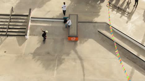 Drone-Sigue-A-Un-Niño-Bajando-Por-Una-Rampa-En-Un-Skatepark,-Medellín,-Colombia