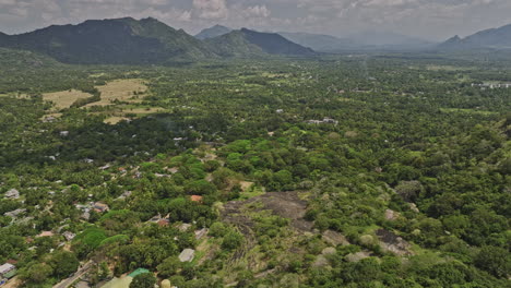 Dambulla-Sri-Lanka-Aerial-v3-drone-flyover-Uyanwaththa-Royal-Buddhist-Temple-capturing-panoramic-views-of-jungle-landscape-and-mountain-views-from-above---Shot-with-Mavic-3-Cine---April-2023