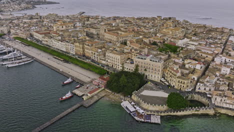 Syracuse-Italy-Aerial-v4-birds-eye-view-drone-fly-along-the-coastal-old-town-capturing-harbor-bay-views,-Arethusa-Spring-and-historical-cityscape-of-Ortigia-Island---Shot-with-Mavic-3-Cine---June-2023