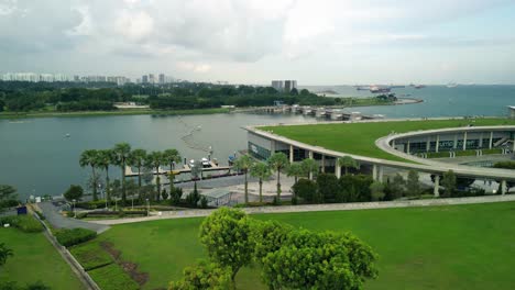 Aerial-over-Marina-Barrage,-an-impressive-engineering-marvel-and-a-vital-part-of-Singapore's-sustainable-development,-acting-as-a-dam-that-prevents-seawater-intrusion-into-the-city's-reservoirs