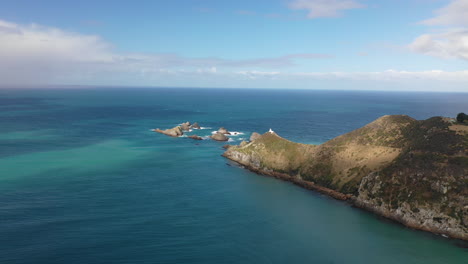 Scenic-aerial-view-of-Nugget-Point-Lighthouse-along-the-rugged-coast-of-New-Zealand's-South-Island