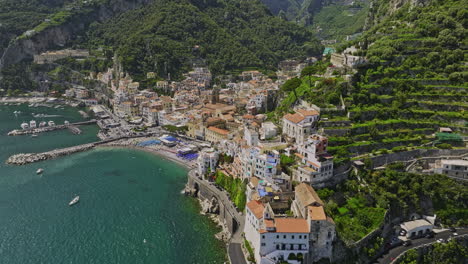 Amalfi-Italy-Aerial-v6-drone-flyover-along-the-coastline-capturing-terraced-hillsides,-charming-coastal-town-center-and-landscape-of-rugged-terrain-and-azure-sea---Shot-with-Mavic-3-Cine---May-2023