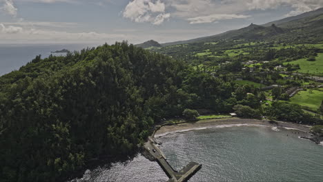 Hana-Maui-Hawaii-Aerial-v7-flyover-bay-beach-park-capturing-village-town,-waterfront-residential-houses-along-rugged-coastline-and-landscape-of-lush-pastures---Shot-with-Mavic-3-Cine---December-2022