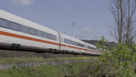 Rear-view-of-High-speed-electric-passenger-train-passing-through-green-valley-in-Frankfurt,-Germany