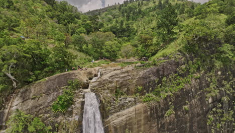 Diyaluma-Sri-Lanka-Aerial-v5-low-flyover-of-cliffside-falls-toward-Upper-Diyaluma-Waterfall,-capturing-jungle-forest-landscape-and-water-cascading-from-the-rocks---Shot-with-Mavic-3-Cine---April-2023
