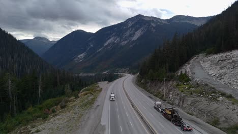 Heavy-Hauler-Semi-Truck-Transporting-Excavator-on-Coquihalla's-Steep-Slope-on-a-overcast-day