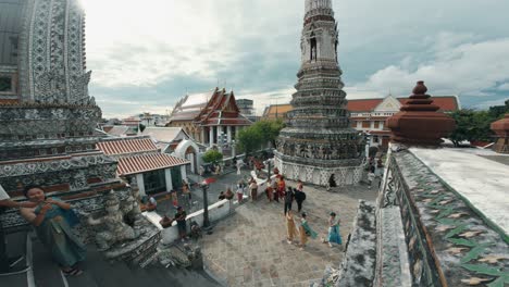Turistas-Explorando-El-Famoso-Templo-Wat-Arun-Ratchawararam,-Situado-A-Orillas-Del-Río-Chao-Phraya-En-Bangkok,-Tailandia