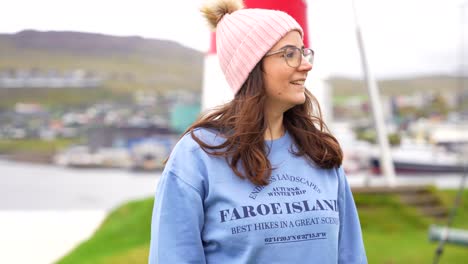Young-woman-smiles-looking-at-the-camera-wearing-a-Faroese-blue-jumper,-Torshavn