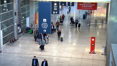 Gruppe-Von-Besuchern,-Die-Die-Ankunftsgates-Des-Pariser-Flughafens-Verlassen,-Handgepäck-Und-Koffer