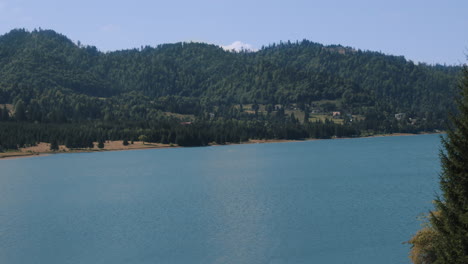 4k-Timelapse-mountain-landscape,-lake-,-green-mountains-rises-above-calm-expanse-of-water