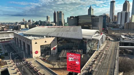 Descend-drone-shot-of-State-Farm-Arena-with-skyline-in-Atlanta-City,-America