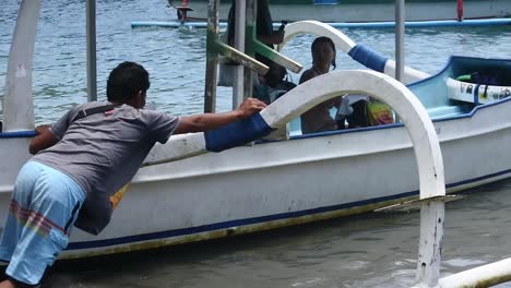 Operator-drives-a-tourist-boat-in-the-coastal-waters-of-Crystal-Bay,-Nusa-Penida-Island,-Bali,-Indonesia