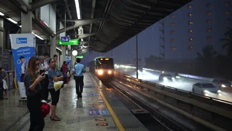 Pasajeros-Esperando-Para-Subirse-Al-Tren-Aéreo-De-Bangkok-En-Medio-De-Una-Fuerte-Tormenta