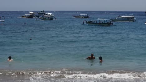 Peoples-are-relaxing-on-the-edge-of-Crystal-Bay-beach,-Nusa-Penida-Island,-Bali
