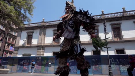 Toma-En-Cámara-Lenta-De-Una-Tribu-Bailando-Con-Su-Disfraz-En-El-Centro-De-La-Ciudad-De-México