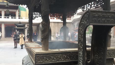 Menschen-Beten-Mit-Brennenden-Räucherstäbchen-Und-Kerzen-Im-Yuyuan-Garten-In-Shanghai,-China,-Mit-Viel-Rauch