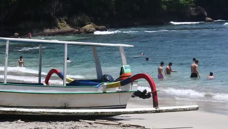 Visitor-are-relaxing-on-the-edge-of-Crystal-Bay-beach,-Nusa-Penida-Island,-Bali