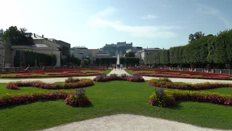 Gardens-of-Mirabell-Palace-with-Fountain-in-the-Middle-and-Fortress-Hohensalzburg-in-Background