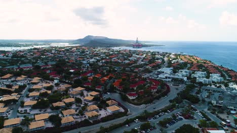 Cloud-shadow-over-neighborhoods-of-Jan-thiel-and-boca-gentil-of-Curacao,-drone-ascend-overview