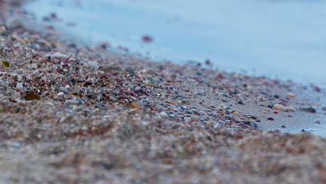 Soft-Focus-Close-View-of-Pebbled-Beach-with-Small-Waves-Out-of-Focus