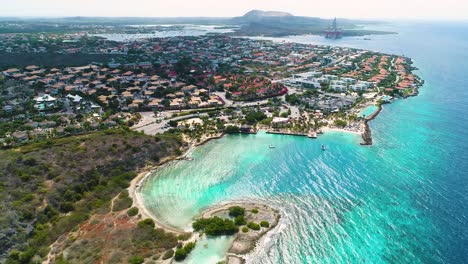 Aerial-parallax-above-Zanzibar-beach,-Jan-Thiel,-Curacao-on-beautiful-blue-sky-day