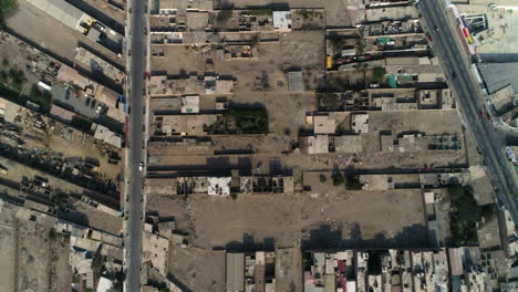 Cenital-drone-shot-flying-above-the-streets-of-Huacho-city,-sunny-day-in-Peru
