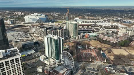 Aerial-landing-shot-of-atlanta-city-by-daytime-with-Ferris-wheel-and-Mercedes-Benz-stadium-in-background