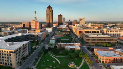 Aerial-view-of-the-Pappajohn-Sculpture-Park-in-Des-Moines,-showcasing-the-modern-sculptures,-green-spaces,-and-surrounding-cityscape,-during-golden-hour-sunset-lighting