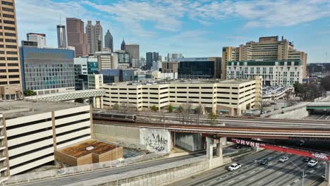 Aerial-establishing-shot-of-train-and-Cars-in-City-of-Atlanta-Downtown-during-sunny-day