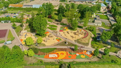 Aerial-view-circling-a-new-playground-and-kids-park-on-a-sunny-summer-evening