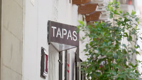 Statisches-Video-Eines-Schildes-Mit-Tapas,-Baum-Im-Vordergrund