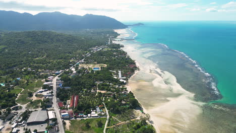Aerial-view-showing-tropical-Koh-Phangan-Island-with-coral-reef,-jungle,-mountains-and-beach-during-foggy-day--Kite-surfing-spot