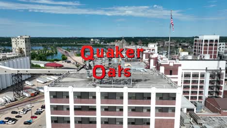 Cedar-Rapids-cityscape-featuring-Quaker-Oats-facility,-modern-buildings,-and-river-backdrop-under-a-blue-sky